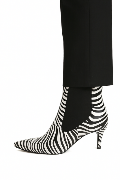 Black and white striped high-heeled boots worn with black pants on a white background